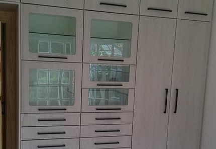 a cabinet with glass doors and drawers